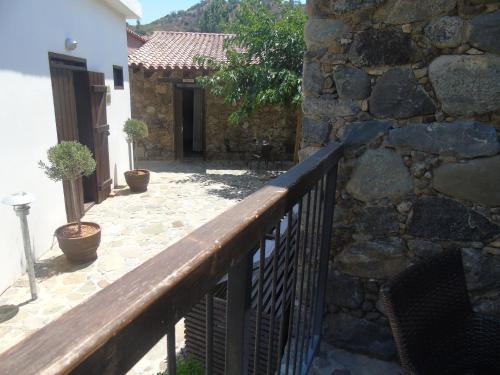 a balcony with a fence and a stone wall at Enipnion Apartments in Kakopetria