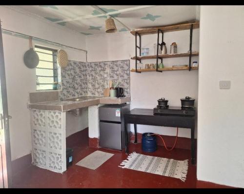 Una cocina con un fregadero y una mesa dentro. en Seaside studio Kilifi, en Kilifi