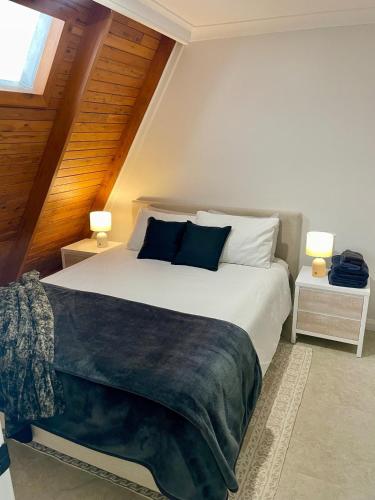 a bedroom with a large white bed with two lamps at Family or Friends Cottage in North Tamborine