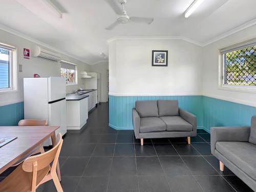 a living room with a couch and a table at Atherton Tourist Park in Atherton