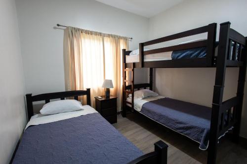 a bedroom with two bunk beds and a window at Casa en puntaleona Condomio Bambu in Quebrada Ganado