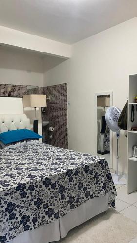 ein Schlafzimmer mit einem Bett mit einer blau-weißen Decke in der Unterkunft Maracarib centro - 200m da praia in Maragogi