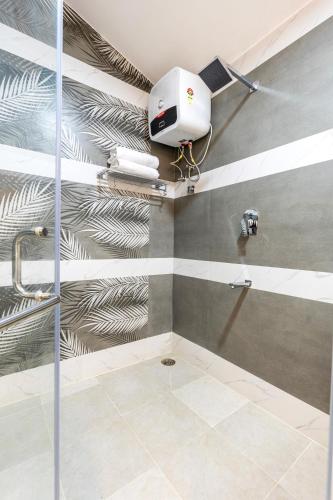 a bathroom with a shower with a camera on the wall at Riverstone Haven in Kotagiri