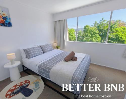 ein Schlafzimmer mit einem Bett und einem großen Fenster in der Unterkunft Comfortable Stay for six and Perfect for Families in Lower Hutt