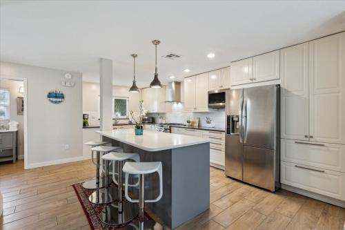 a kitchen with white cabinets and a island with bar stools at 10 Colonial Drive in Cocoa Beach