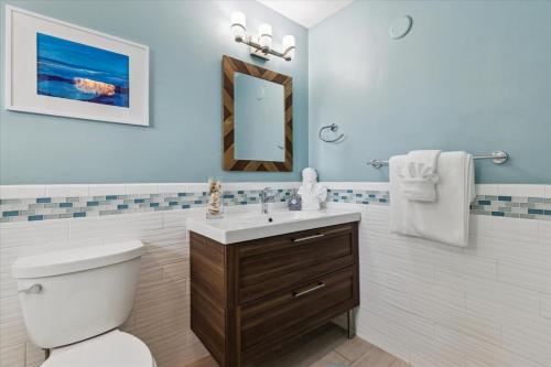Un baño con inodoro, lavabo y espejo. en 10 Colonial Drive, en Cocoa Beach