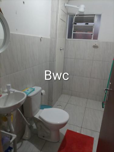 a bathroom with a white toilet and a sink at Lar Doce Lar in Garanhuns