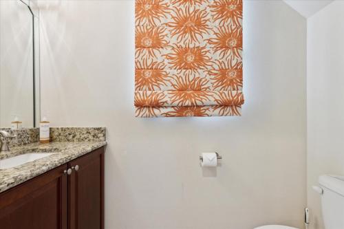 a bathroom with a toilet and a painting on the wall at Cape Crossing 106 in Merritt Island