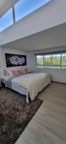 a bedroom with a large bed in a room with windows at Casa Villa Container in Tibasosa