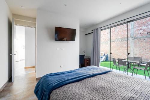 a bedroom with a bed and a table with chairs at Casa Viña Sol - Vive la ruta del Vino y del Pisco in Ica