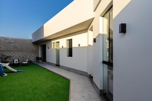 einen Innenhof eines Hauses mit grünem Gras in der Unterkunft Casa Viña Sol - Vive la ruta del Vino y del Pisco in Ica