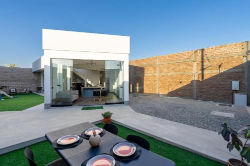 eine Terrasse mit einem Tisch und Stühlen im Hinterhof in der Unterkunft Casa Viña Sol - Vive la ruta del Vino y del Pisco in Ica