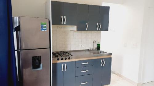 Una cocina con frigorífico de acero inoxidable y fregadero. en Tranquilidad y confort en un solo lugar, en Apartadó