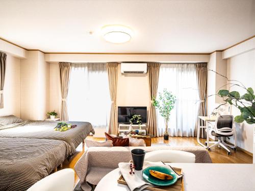 ein Schlafzimmer mit zwei Betten und ein Wohnzimmer in der Unterkunft The Global West in Niihama