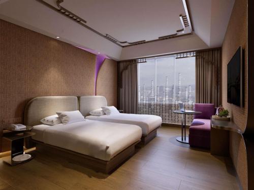 Una habitación de hotel con dos camas y una ventana. en Mercure Surabaya Grand Mirama, en Surabaya