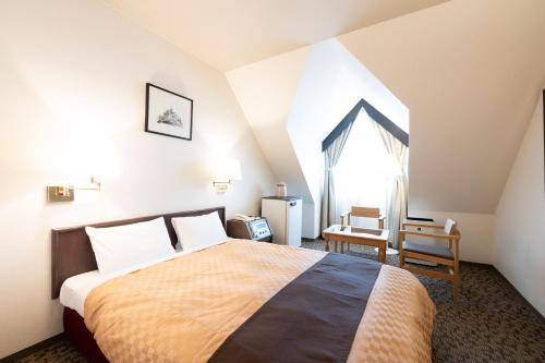 a bedroom with a large bed and a window at Hotel Edel Warme in Furano