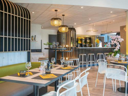a restaurant with tables and chairs and a bar at ibis Styles Pertuis Portes du Luberon in Pertuis
