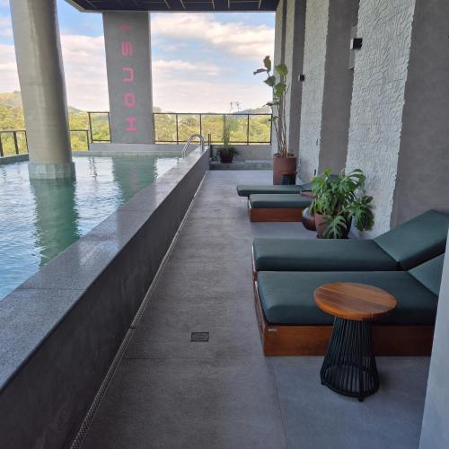 a hotel lobby with a pool with chairs and a table at SKY Alphaville in Barueri