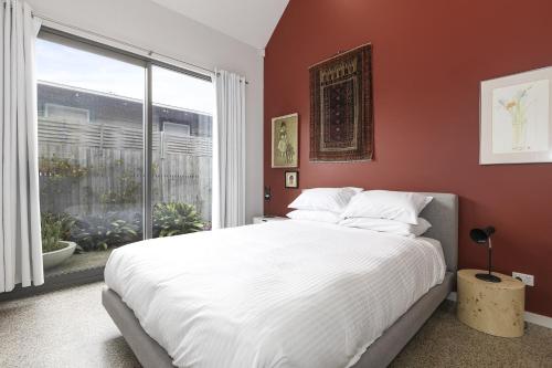 ein Schlafzimmer mit einem großen Bett und einem großen Fenster in der Unterkunft Spacious 1-Bed Townhouse in Norlane in Norlane