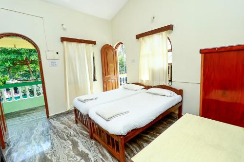 a bedroom with two beds and a window at Caphina Coastal Comforts in Benaulim