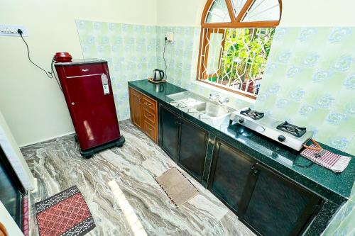 a kitchen with a counter and a sink and a window at Caphina Coastal Comforts in Benaulim