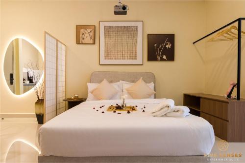 ein Schlafzimmer mit einem großen weißen Bett und einem Spiegel in der Unterkunft KIP Core Soho Suite by Five Senses in Sepang