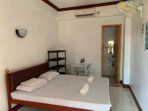 a room with a bed and a bathroom with a sink at First Baby Bytes Guest House in Lazi