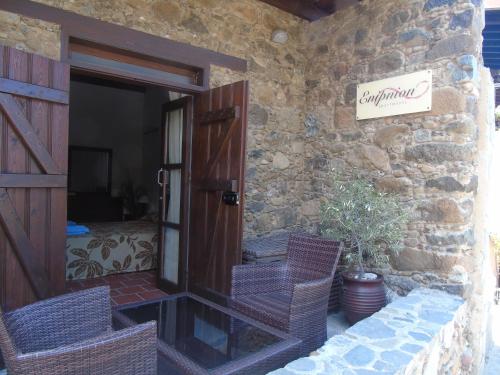 a stone building with a door and two chairs at Enipnion Apartments in Kakopetria