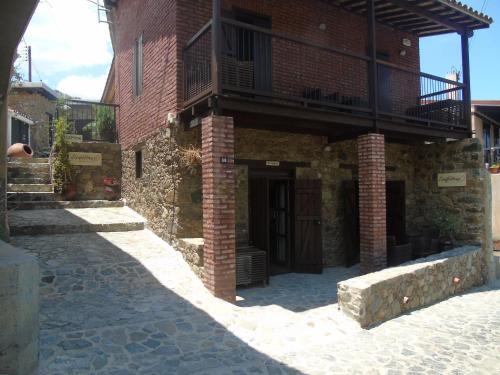 a brick building with a balcony on top of it at Enipnion Apartments in Kakopetria