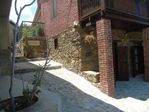 an old brick building with a door and a tree at Enipnion Apartments in Kakopetria