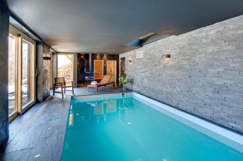 einen Pool in einem Zimmer mit Ziegelwand in der Unterkunft Superb Chenalette Chalet in Morzine