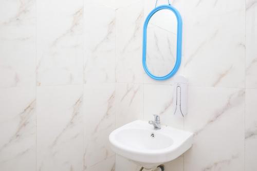 ein Badezimmer mit Waschbecken und Spiegel an der Wand in der Unterkunft RedDoorz Syariah near Pengadilan Agama Wonosobo in Wonosobo