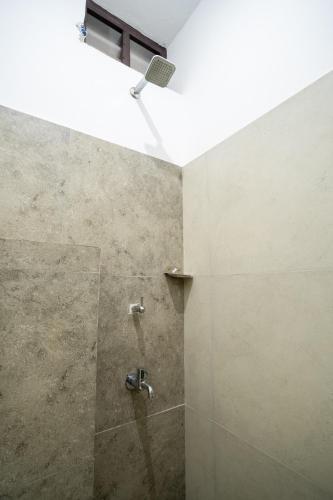 a bathroom with a shower with a shower head at Infinity Rooms Kazhakkoottam Technopark in Trivandrum