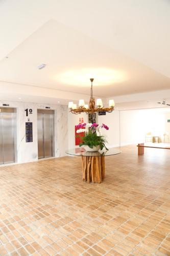 a large room with a table and a chandelier at Vitória Hotel Express Dom Pedro in Campinas