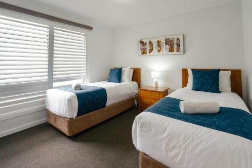 Giường trong phòng chung tại Waves Motel and Apartments formerly Comfort Inn International