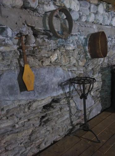 a stone wall with a wooden spatula and a mortar at Guest House Keti Margiani Mestia in Mestia