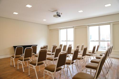 an empty room with chairs and a podium in it at Vitória Hotel Express Dom Pedro in Campinas