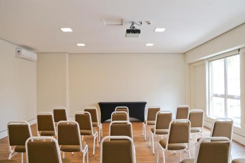 a room with a bunch of chairs in front of a screen at Vitória Hotel Express Dom Pedro in Campinas