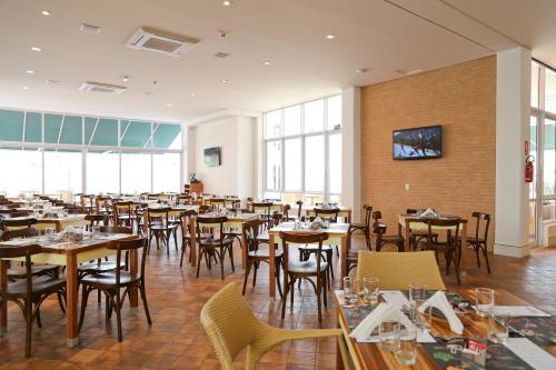a dining room filled with tables and chairs at Vitória Hotel Express Dom Pedro in Campinas