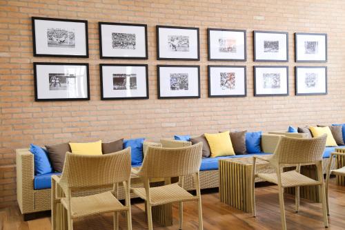 a living room with a blue couch and chairs at Vitória Hotel Express Dom Pedro in Campinas