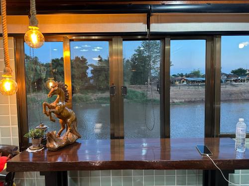 a table with a statue of a horse on it at อิ๊กขะหลิ๊ก โฮมสเตย์ริมน้ำน่าน in Nan