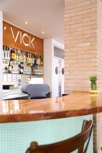 a bar in a restaurant with a counter and chairs at Vitória Hotel Express Dom Pedro in Campinas