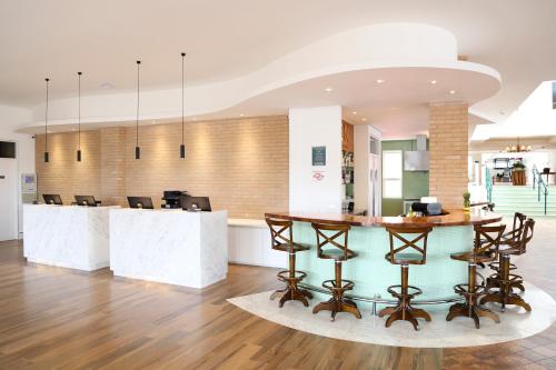 a lobby with a table and chairs in a building at Vitória Hotel Express Dom Pedro in Campinas