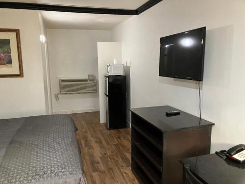 a room with a desk and a television on the wall at Budget Host Inn in Arlington