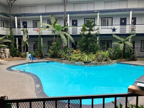 a large blue swimming pool in front of a building at Budget Host Inn in Arlington