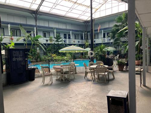 a patio with tables and chairs and a pool at Budget Host Inn in Arlington