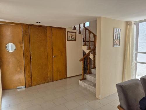 a living room with wooden cabinets and a staircase at Casa puebla univ Politecnico in Puebla