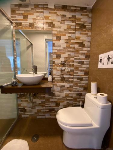 a bathroom with a white toilet and a sink at Lince Apartments in Lima