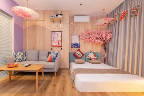 a bedroom with a bed and a couch and a table at Guangzhou Xingdu International Youth Hotel Apartment Hostel-Near Canton Fair And Canton Tower in Guangzhou