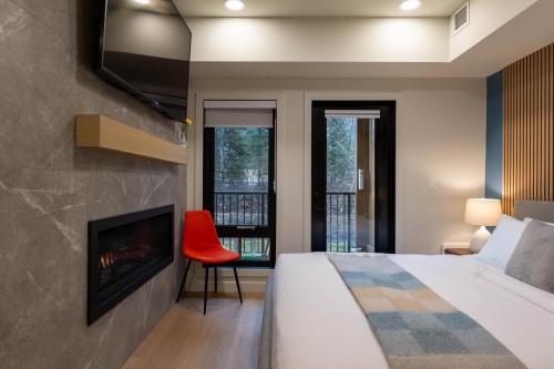 een slaapkamer met een bed, een open haard en een tv bij Brand New Canmore Studio - Cozy Mountain Getaway in Canmore